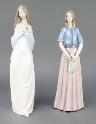 A Nao figure of a standing girl holding a posy no.1344 14" and a do. of a girl holding a towel no.1255 13" 