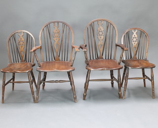 A set of 4 elm Windsor wheelback dining chairs with solid seats, on turned supports with H framed stretchers - 2 carvers, 2 standard 