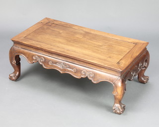A rectangular Chinese carved hardwood "opium" table with shaped and carved apron raised on claw and ball supports 12" x 30" x 16" 