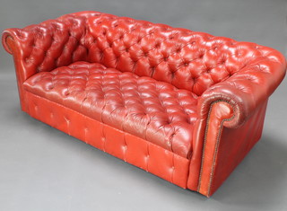 A Chesterfield upholstered in red buttoned leather 26"h x 72"w x 34"d 