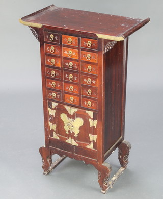 A Chinese hardwood cabinet fitted 18 shallow drawers above cupboard with gilt metal mounts 29"h x 18 1/2"w x 10"d 