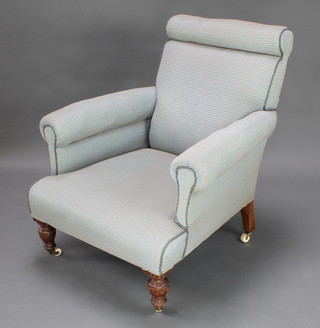 A Victorian Howard style armchair upholstered in blue material raised on turned walnut supports 