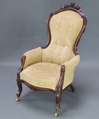 A Victorian mahogany show frame armchair upholstered in yellow material raised on cabriole supports 