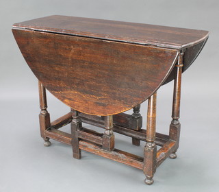 An 18th Century oak oval drop flap gateleg tea table raised on turned supports 28"h x 40"w x 16" when closed x 45" when open