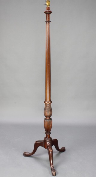 A Georgian style turned and fluted mahogany standard lamp raised on pillar and tripod supports with egg and claw feet 60"