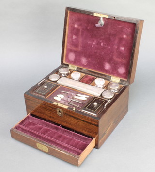 A Victorian rosewood and inlaid mother of pearl vanity box with secret drawer, the hinged lid revealing a fitted interior with various manicure implements and glass jars, marked by Made by Mechi of 4 Leadenhall Street London 6"h x 11"w x 8 1/2"d 