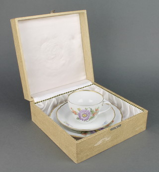 A 20th Century German porcelain tea cup, saucer and plate decorated with spring flowers, boxed 