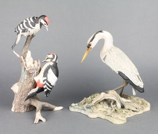 A Teviotdale composition figure of a heron by D Edlmann no.358/500 9" and a porcelain group of woodpeckers 11" 