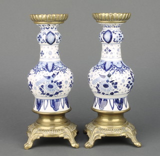 A pair of Delft baluster vases decorated with birds and flowers raised on a brass base with brass cover 9 1/2" 