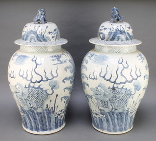 A pair of Chinese blue and white antique style baluster vases and covers with Shi Shi finial decorated with leaves and clouds 27" 