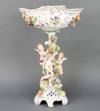 A late 19th Century German porcelain centrepiece, the pierced bowl supported by 3 cavorting angels on a raised Rococo base with applied flowers 18" 