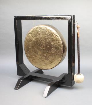 A circular 14" Chinese gilt metal gong, raised on a black stand 