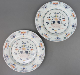 A pair of 18th Century English Delft polychrome plates decorated with a basket of flowers within floral border, possibly Lambeth, 9" 