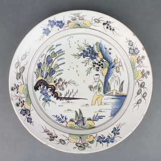 An 18th Century English Delft polychrome dish decorated in the chinoiserie style with a gentleman in a garden enclosed in a floral border 11 1/2" diam. 