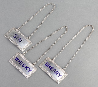A set of 3 silver and enamelled spirit labels - Whisky, Sherry, Gin, Birmingham 1947 