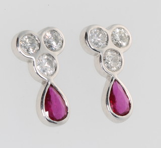 A pair of 18ct white gold ruby and diamond ear studs, the pear cut rubies approx. 0.83ct surmounted by 3 brilliant cut diamonds approx. 0.99ct 