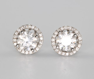 A pair of 18ct white gold diamond ear studs, the centre stones approx 1ct each, surrounded by brilliant cut diamonds approx. 0.23ct 