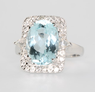 An 18ct white gold aquamarine and diamond ring the centre oval cut stone approx. 4.2ct surrounded by brilliant cut diamonds approx. 0.51ct size N 