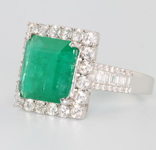 An 18ct white gold square cut emerald and diamond cluster ring, the centre stone approx. 3.95ct surrounded by brilliant cut diamonds approx. 1.24ct size N