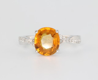 A 14ct white gold yellow sapphire and diamond ring, the centre stone approx. 2.7ct surrounded by brilliant cut diamonds approx. 0.15ct size M 