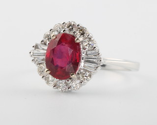 An 18ct white gold ruby and diamond cluster ring, the centre stone approx 1.8ct flanked by brilliant and tapered baguette cut diamonds approx. 0.58ct size N 1/2