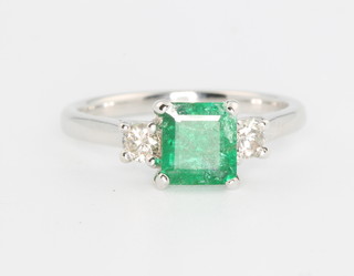 An 18ct white gold emerald and diamond ring, the centre square stone approx 0.94ct flanked by brilliant cut diamonds approx. 0.22ct, size M 