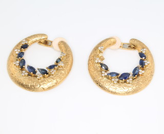 A pair of stylish 1970's 18ct yellow gold sapphire and diamond ear clips, the textured gold hoops each set with 24 brilliant cut diamonds and 7 marquise cut sapphires 35mm wide, gross weight 21 grams