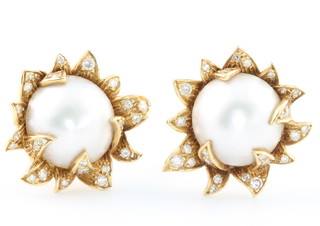 A pair of stylish 1970's 18ct yellow gold pearl and diamond ear clips 15mm pearls surrounded by brilliant cut diamonds, stamped OR, 25mm wide, gross weight 17.7 grams 