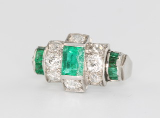 A white gold Art Deco cocktail ring set with 5 baguette cut emeralds and 8 brilliant cut diamonds, size F 1/2