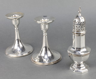 An octagonal silver shaker Birmingham 1927 7" and a pair of stylish silver candlesticks of tapered form Birmingham 1918  5" 