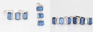 A suite of 18ct white gold, sapphire and diamond jewellery comprising pendant, ear clips and ring - size O, set  baguette cut sapphires and brilliant cut diamonds
