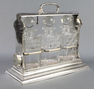 An Edwardian plated 3 bottle tantalus with patent action opening 