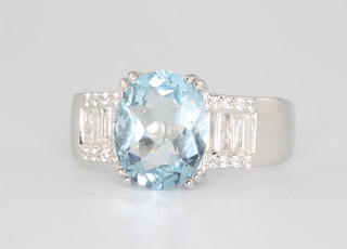 An 18ct white gold aquamarine and diamond ring, the oval cut centre stone approx. 2.19ct flanked by 4 brilliant cut diamonds approx. 0.31ct and 16 brilliant cut diamonds approx. 0.09ct size N 