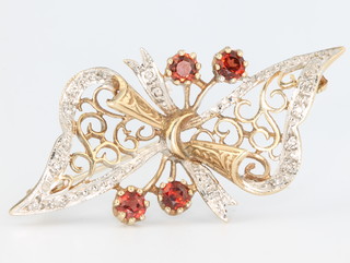 A 9ct yellow gold garnet and diamond open bow brooch