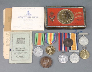 A World War One pair to 112829 TNR. B. W. Cox.R.A, a Victory medal, 3 Second World War medals, an identity card to T Flatt contained in a South Africa 1900 chocolate tin 