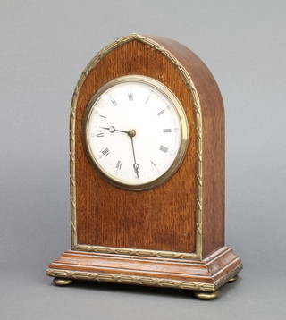 A French bedroom timepiece with enamelled dial and Roman numerals contained in an oak and gilt metal lancet case 