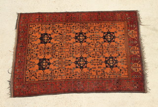 A rust ground Afghan rug with 6 stylised medallions with floral borders 70" x 49" 