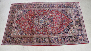 A Persian red and blue ground carpet with central medallion within multi row borders 129" x 79 1/2" 