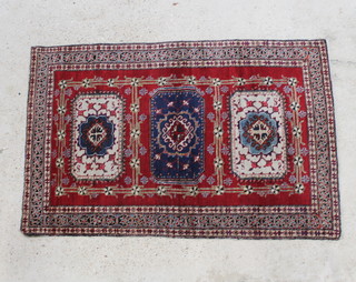 A red and blue ground Caucasian rug with 3 rectangular medallions to the centre 64" x 42"