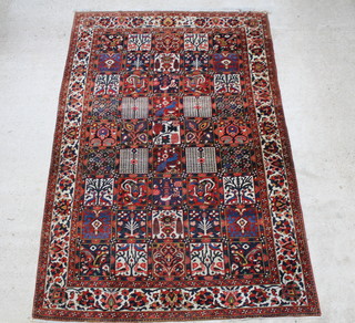 A Persian Bakhtiari carpet the centre formed of 45 panels depicting flowers and within a multi row border 112" x 84"