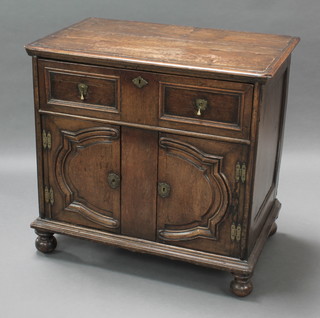 An 18th Century style oak Dutch cabinet fitted 1 long drawer the base fitted cupboards enclosed by shaped panelled doors, raised on bun feet 34"h x 36"w x 22 1/2"d 