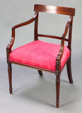 A 19th Century mahogany bar back carver chair with plain mid rail and upholstered seat raised on turned and reeded supports