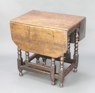 An 18th Century oak drop flap gateleg dining table, fitted a frieze drawer and raised on bobbin turned supports 28"h x 28"w x 18" when closed x 43 1/2"l when open 