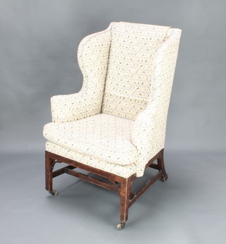 A George III mahogany wing armchair upholstered in tapestry material 