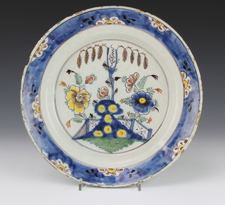 An 18th Century English Delft polychrome dish decorated with a garden view in a floral border 12" 