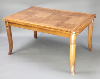 A 1930's Art Deco oak draw leaf dining table with parquetry style top raised on out swept supports 30"h x 39"w x 57" when closed x 101" when extended