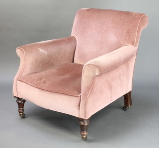 A Victorian Howard style armchair upholstered in rose pink Dralon, raised on turned supports