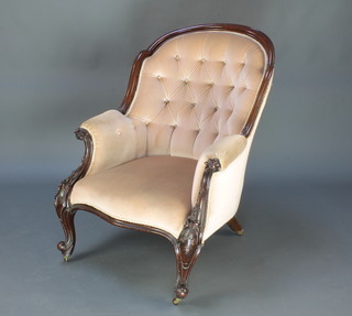 A Victorian showframe rosewood armchair upholstered in peach coloured buttoned Dralon, raised on cabriole supports  