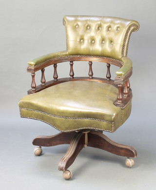 A tub back revolving office chair upholstered in green buttoned leather 