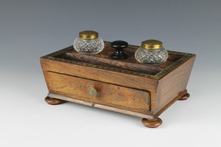 A rectangular Regency rosewood and brass inlaid standish of waisted form with 2 pen receptacles and 2 cut glass inkwells, base fitted a drawer, raised on bun feet 3 1/2" x 8 1/2" x 6 1/2" 
